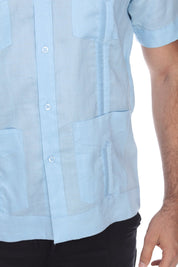 Men’s light blue short sleeve guayabera shirt featuring a traditional 4-pocket layout and breathable cotton-blend fabric.