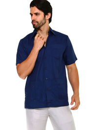 Man wearing a dark navy blue guayabera shirt featuring embroidered heritage accents and a breathable cotton-blend fabric.
