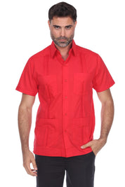 A man wearing a bright red short-sleeve button-up shirt with a collar, two chest pockets, and two large front patch pockets, paired with black pants, against a plain white background.