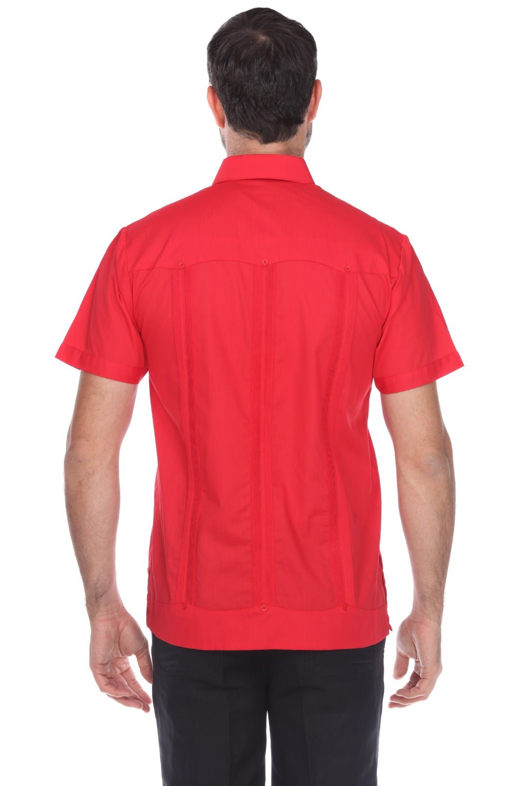 A man viewed from the back wearing a bright red short-sleeve button-up shirt and black pants, photographed against a plain white studio background.