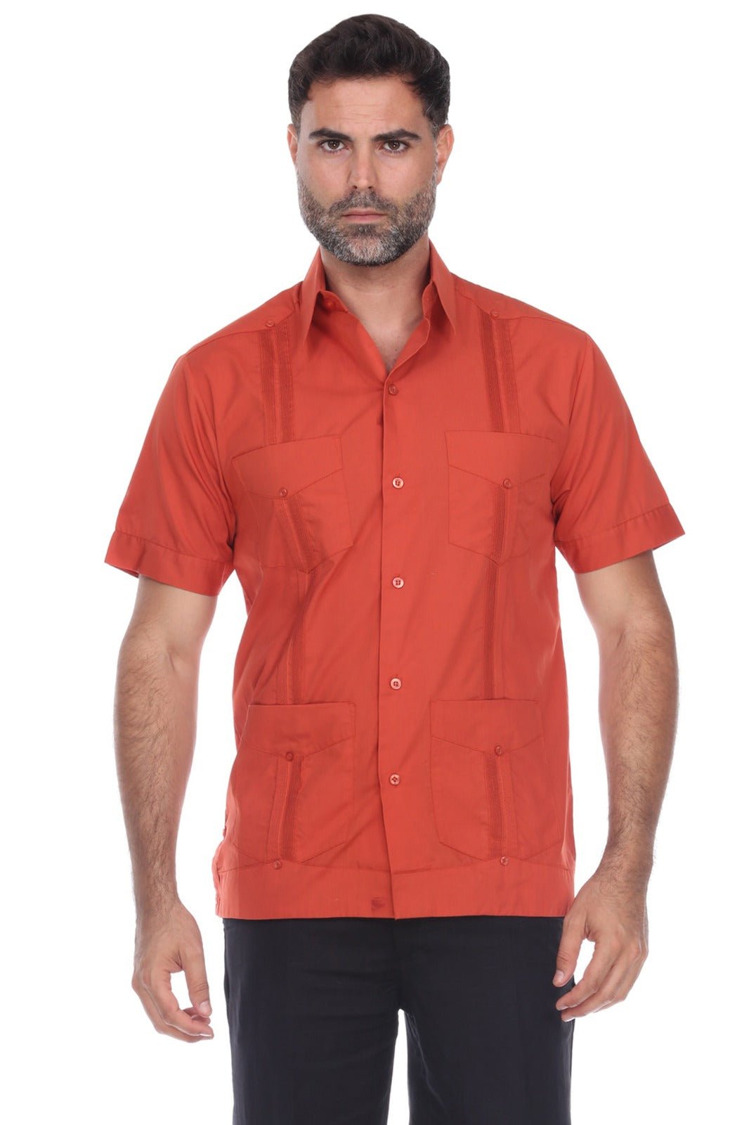 A man wearing a short-sleeve button-up shirt in a muted terracotta or burnt orange color, paired with black pants, photographed against a plain white background.