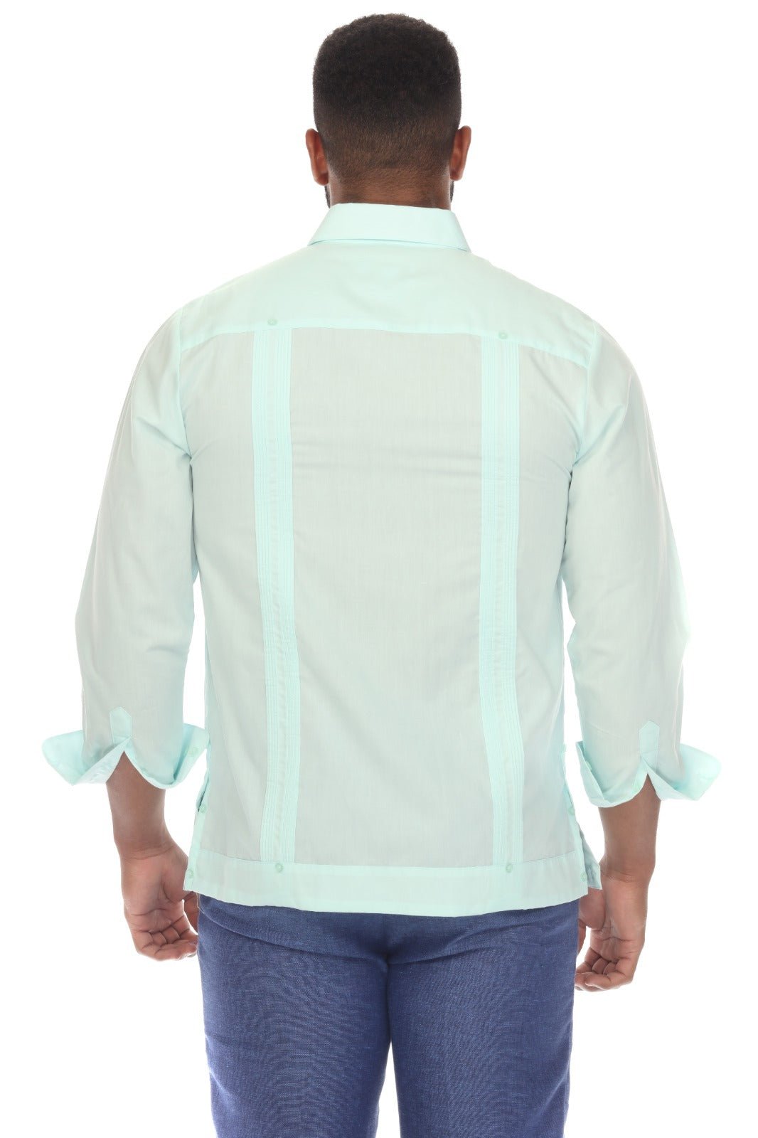 A man viewed from the back wearing a mint green Guayabera-style shirt with vertical mesh panels and ruffled cuffs, paired with blue jeans, against a plain white background.