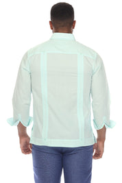 A man viewed from the back wearing a mint green Guayabera-style shirt with vertical mesh panels and ruffled cuffs, paired with blue jeans, against a plain white background.