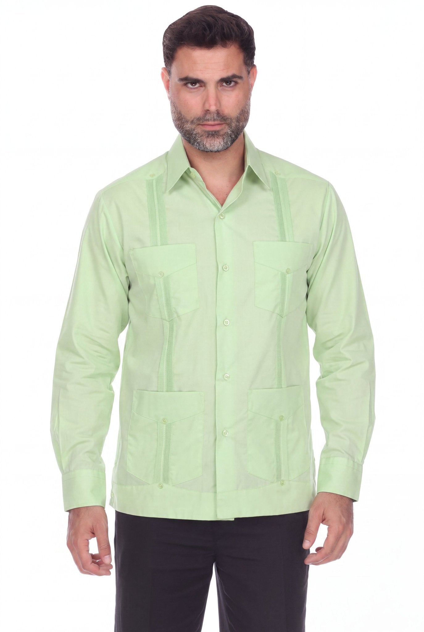 A man wearing a light green guayabera-style button-up shirt with vertical pleats and front chest pockets, paired with black pants, against a plain white background.