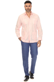 A man modeling a light pink long-sleeve guayabera-style shirt with blue jeans and black shoes, standing against a plain white background.