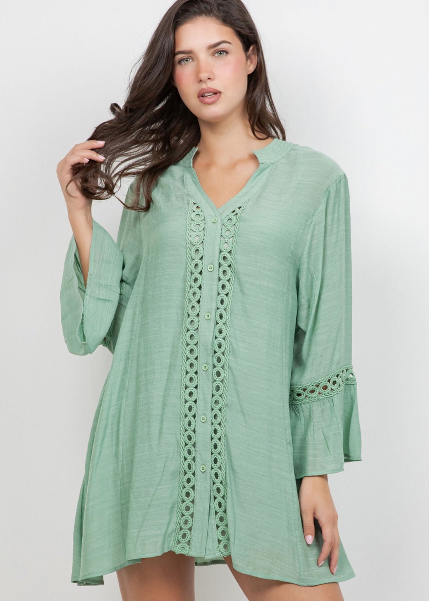 Model wearing the Ladies Boho Lace Trim Tunic Dress set, a light green mini dress with lace accents.