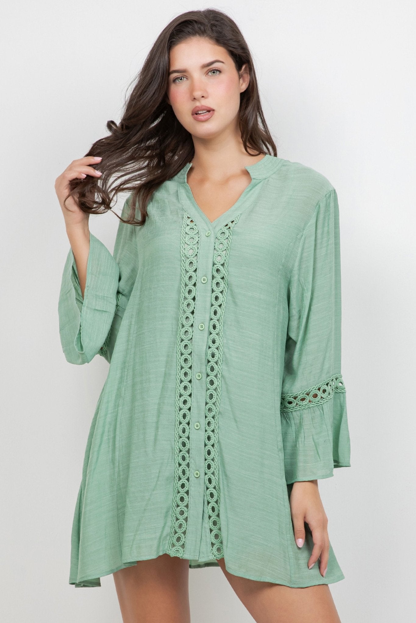 Model wearing the Ladies Boho Lace Trim Tunic Dress set, a light green mini dress with lace accents.
