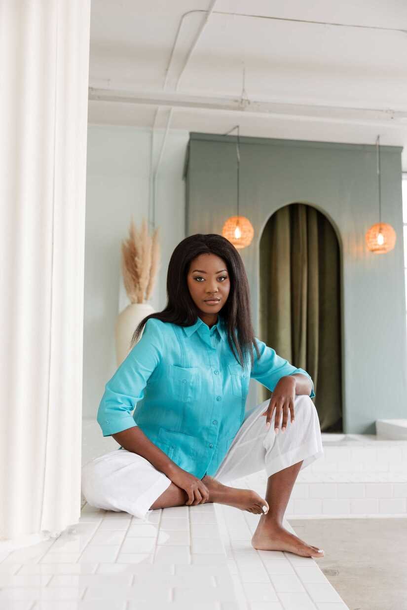 Premium linen guayabera shirt for women in a vibrant turquoise color, perfect for warm-weather events.