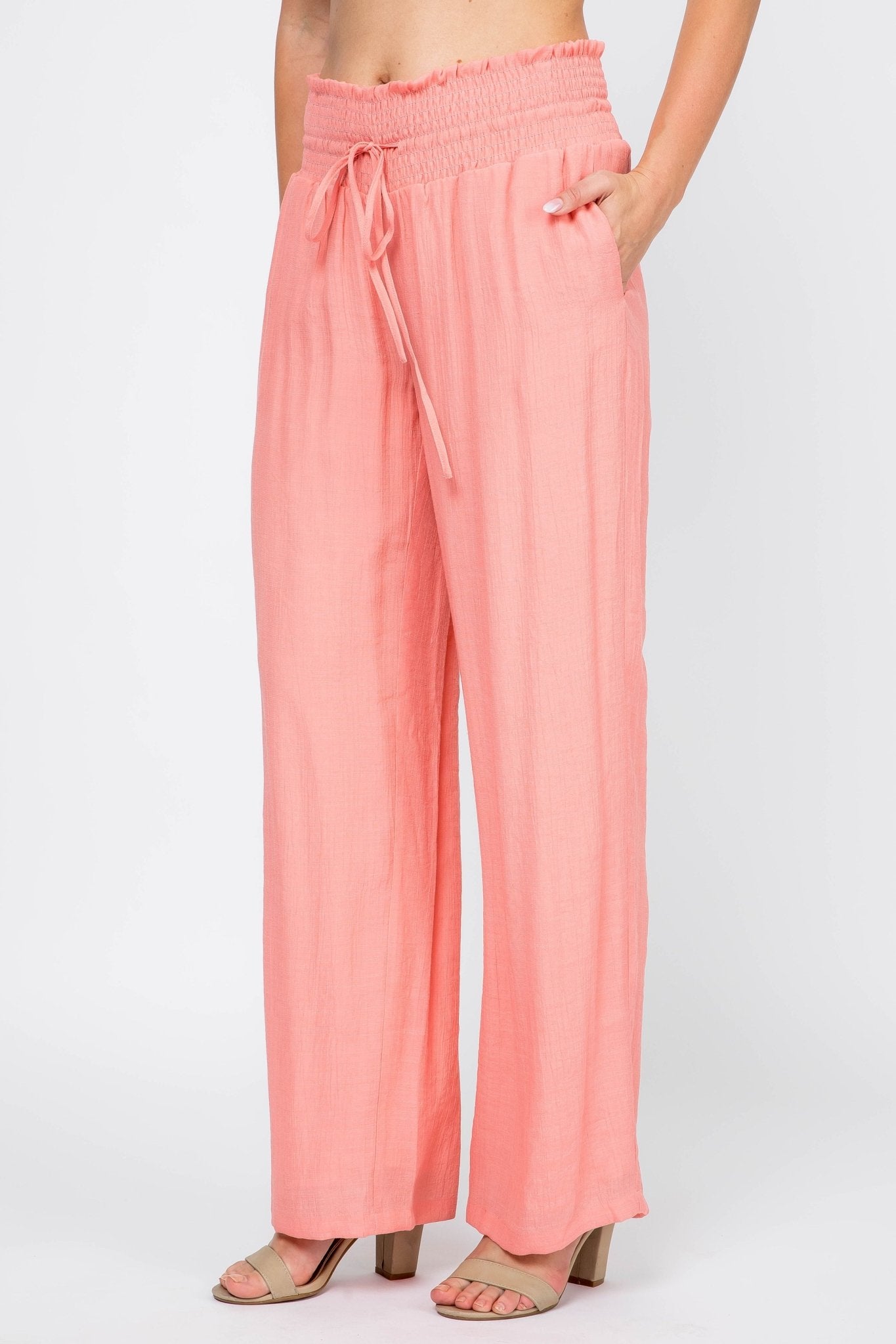 Model wearing peach Ladies Smocked Waist Drawstring Palazzo Pants, shown with hand in pocket.