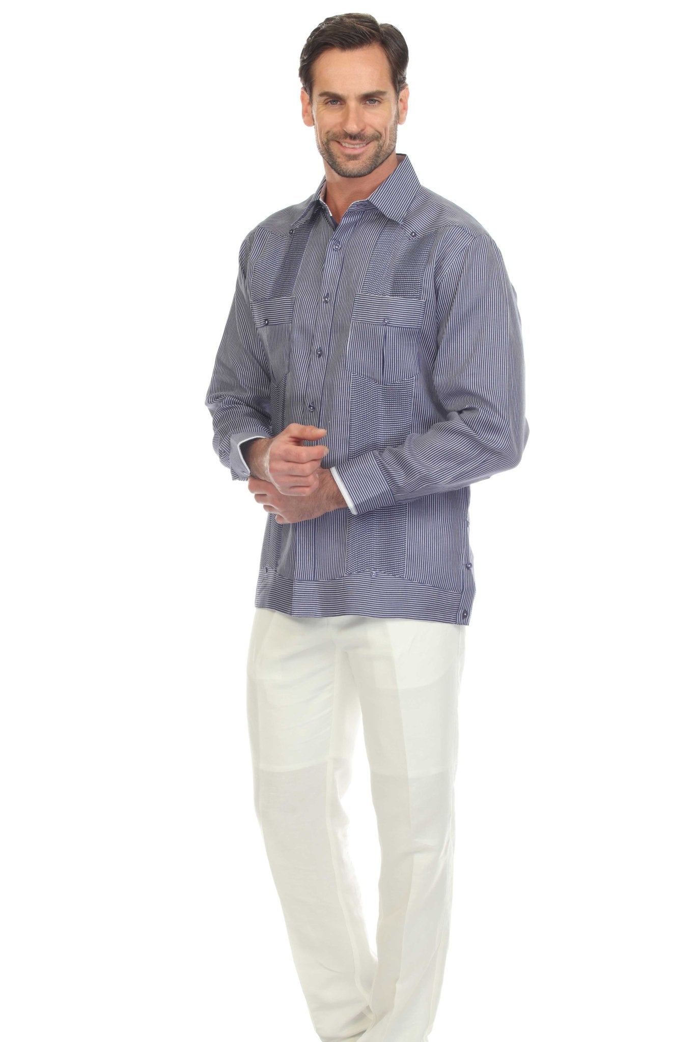 A man wears a striped blue and white 100% Linen Contrast Panel Guayabera Shirt Long Sleeve with white linen pants.