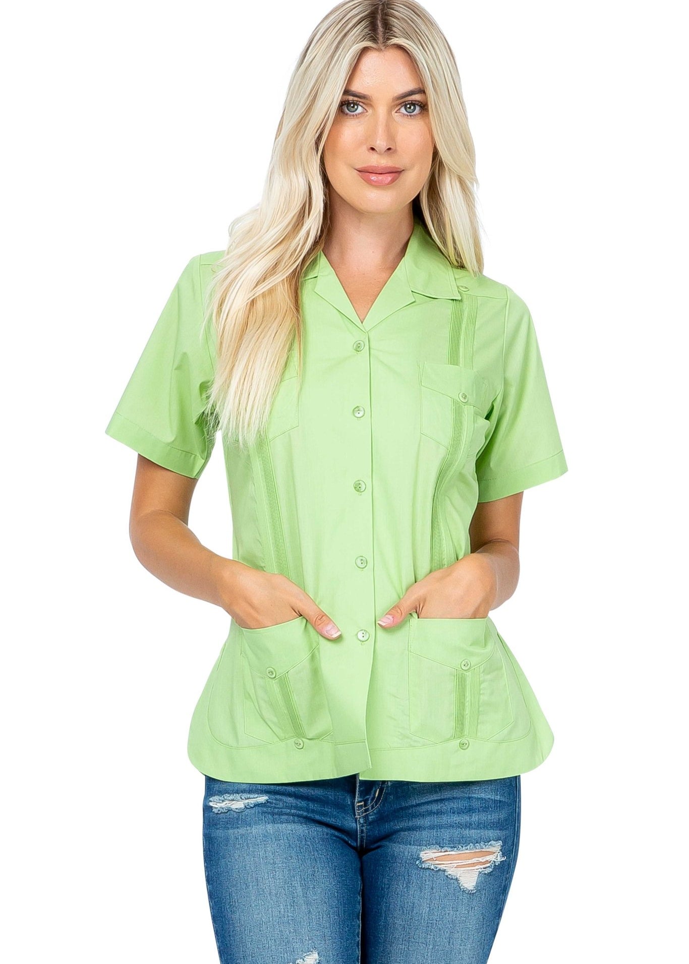 A woman models a light green, short sleeve Women's Short Sleeve Guayabera with 4 Pockets, hands in the bottom pockets.