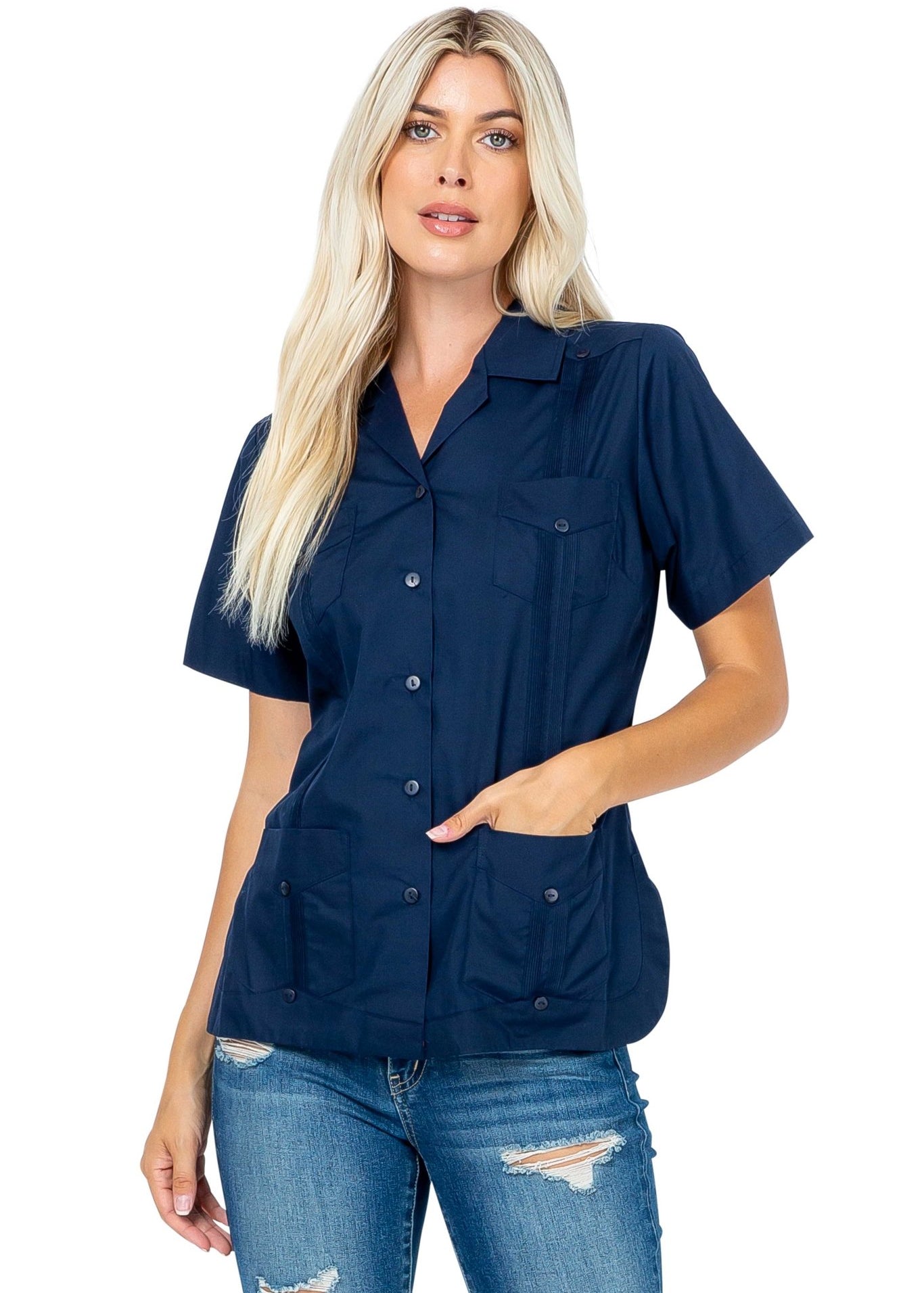 A woman models a navy blue Women's Short Sleeve Guayabera with 4 Pockets, her hand resting in one of the lower pockets.