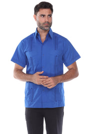 Medium shot of the blue short sleeve guayabera highlighting the structured look and traditional four-pocket styling.