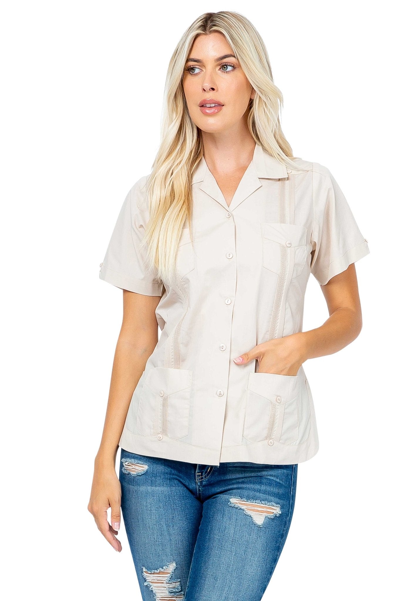 A woman models the beige Women's Short Sleeve Guayabera with 4 Pockets, wearing jeans and with one hand in a pocket.