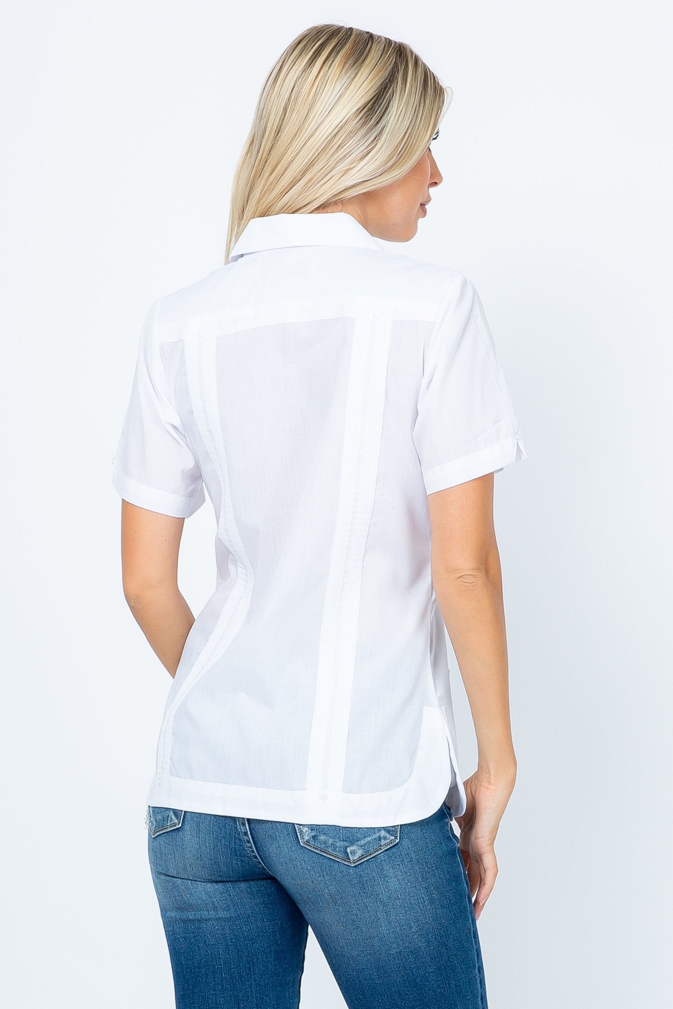 Back view of a woman wearing a white short sleeve Guayabera with vertical pintuck details.