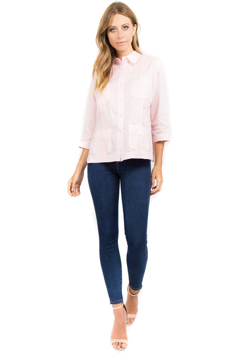 Full body view of a Light Pink Women's 100% Linen Guayabera Shirt styled with denim for a resort look.
